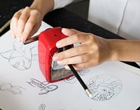 Woman Sharpen Pencil On A Black Table