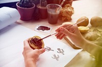 Woman painting potatoes on wooden desk