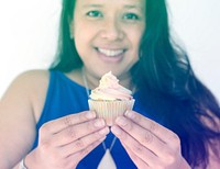 Woman smiling and holding cupcake dessert