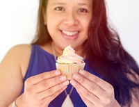 Woman smiling and holding cupcake dessert