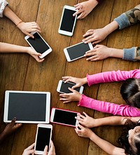 Group of Kids Holding Digital Devices Connect on Wooden Table