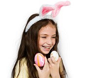 Kid with a bunny hairband holding eggs