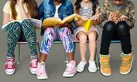 Diverse group of kids sitting in a row reading books