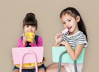 Two young girls sitting on a chair portrait