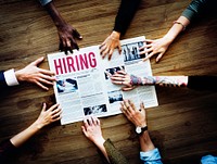 Diverse People Hands Reach Out for Hiring Newspaper Announcement