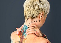 Shorthaired blonde woman with tattoos on her back