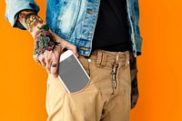 Tattooed hand with a mobile phone in the pocket