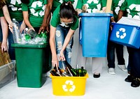 People in group helping together to put up bottles for recycle