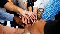 Group of people putting hands together