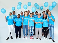 Group of volunteer people smiling and holding balloons