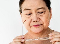 Senior Adult Asian Woman Taking off Eyeglasses