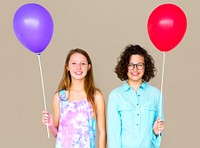 Two girl is holding a color balloon