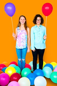 Young Adult Women Holding Balloons Together Studio Portrait