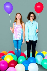 Young Adult Women Holding Balloons Together Studio Portrait