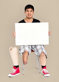 Disability Young Man with Prosthesis Leg Holding Blank Paper Board Studio Portrait
