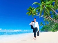 Businessman walking along the tropical beach.