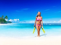 Smiling woman with scuba gear on a tropical beach.