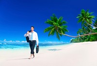 Businessman walking along the tropical beach.