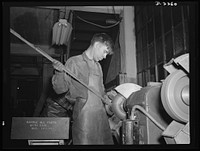 Bantam, Connecticut. Buffing aluminum supports for bomber seats is nineteen-year-old Gerard Gervais, who came to Bantam in the fall of 1941 with his older brother Ernest from Plainfield, Connecticut. The two brothers share a five-room house in Bantam with two aunts and an uncle, who also came to Bantam during 1941 to work at the Warren McArthur plant. Sourced from the Library of Congress.