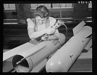 Conversion. Toy factory. With this same electric screwdriver, Stephanie Cewe used to work on the manufacture of toy trains. Now she's using it in far more important work--that of assembling flare casings. A. C. Gilbert Company, New Haven, Connecticut by Howard R. Hollem
