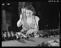 Conversion. Toy factory. From toy trains to parachute flare casings is the work history of Stephanie Cewe, whose skill with this electric screwdriver has been turned to the aid of Uncle Sam's war machine. Here she is shown at her former job--assembling locomotives for toy trains. Today she operates the same screwdriver in her assembly work on flare casing. A. C. Gilbert Company, New Haven, Connecticut. Sourced from the Library of Congress.