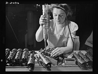Conversion. Toy factory. From toy trains to parachute flare casings is the work history of Stephanie Cewe, whose skill with this electric screwdriver has been turned to the aid of Uncle Sam's war machine. Here she is shown at her former job--assembling locomotives for toy trains. Today she operates the same screwdriver in her assembly work on flare casing. A. C. Gilbert Company, New Haven, Connecticut by Howard R. Hollem