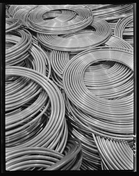 Conversion. Copper and brass processing. Coils of copper water tube. Large quantities of copper tube are needed by our Army and Navy, and vital industries. The smaller sizes are used for oil lines on equipment producing defense products and for fuel lines on tanks and other mechanized equipment. Single lengths up to sixty feet are coiled for convenience in handling and shipping. Chase Copper and Brass Company, Euclid, Ohio by Alfred T. Palmer