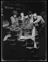 Conversion. Copper and brass processing. These men are pushing a factory platform truckload of coiled brass and copper strips to the shipping platform of the mill. Chase Copper and Brass Company, Euclid, Ohio. Sourced from the Library of Congress.
