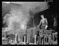 Conversion. Copper and brass processing. In the brass and copper casting shop, the operator of an electric furnace is pouring the molten metal into molds to form shells, or rough tubes, which are later formed into finished tubes. Tubes are formed by casting molten metal into these molds in which a refractory core has been inserted. The molds are mounted on a turntable, which brings them into position to receive the pouring. Chase Brass and Copper Company, Euclid, Ohio. Sourced from the Library of Congress.