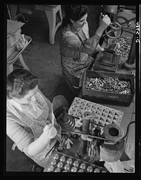 Conversion. Electric shaver plant. Before and after! This New England plant, whose normal product is electric dry shavers, now is converting to the production of machine tool parts to speed war production. At the right the worker is drilling pressure pinholes in the heads of the shavers; at the left the worker drills center holes in the spring collets which will be used to hold the work in turning machines now being made for the war production effort. Schick Inc., Stamford, Connecticut. Sourced from the Library of Congress.