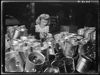 Aluminum casting. Womens' place in this large Midwest aluminum factory is on the inspection line. She's giving a final checkup on these aluminum pistons which are destined for use by America's armed forces. Destination of the finished aluminum products is kept secret. They'll probably end up as jeep or airplane engine parts. Aluminum Industries Inc., Cincinnati, Ohio. Sourced from the Library of Congress.