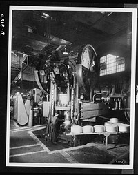 Conversion. Beverage containers to aviation oxygen cylinders. The huge press which formed the beverage containers shells pictured here has since been converted to produce oxygen cylinders, required by the U.S. Army for high altitude flying. The conversion was accomplished by substituting new dies. Firestone, Akron, Ohio. Sourced from the Library of Congress.