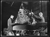 A rugged, efficient power plant goes aboard the chassis of a halftrac scout car an Ohio truck plant is producing for our new mechanized Army. White Motor Company, Cleveland, Ohio. Sourced from the Library of Congress.