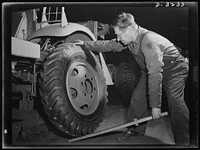 Mounting a wheel on a halftrac scout car is made as simple a job as possible. The soldier in the field won't have the uniform working conditions of the man on an Ohio assembly line, but the tire mounting job is the same. White Motor Company, Cleveland, Ohio. Sourced from the Library of Congress.