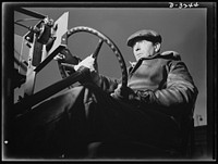 The chassis of an Army halftrac scout car get a workout. When this test driver at a large Midwest plant has put the machine through its paces, he'll know if the machine meets the exacting specifications of the Army. White Motor Company, Cleveland, Ohio. Sourced from the Library of Congress.