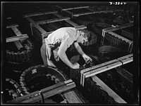 The serial numbers of each track for Army halftrac vehicles crated for shipment from a Midwest tire plant are given a final check. Goodrich, Akron, Ohio. Sourced from the Library of Congress.