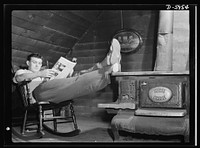 Manpower. Americans all. Machining medium tank parts in a Midwest plant during most of the daylight hours leaves Joe Gore, Jr., in a quite weary state when evening rolls around. Of Polish-born parents, Joe's home shows vestiges of "old country" influences, but his own personal attic sanctum is solid Americana. Note the Home Bride, and the rocker that any mountain home would welcome. Pressed Steel Can Company, Chicago, Illinois. Sourced from the Library of Congress.