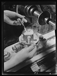 Production. Machine guns of various calibers. Machining a switch pivot for a machine gun in a large Eastern plant. Women's hands are playing a prominent role in this plant producing essential weapons for the armed forces. Sourced from the Library of Congress.