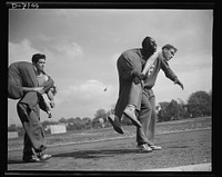 High school Victory Corps. The fireman's "carry." The correct method of carrying a wounded comrade, is shown here by some of the boys in the  "commando" course which is part of the physical education program of Flushing High School, Queens, New York. Sourced from the Library of Congress.