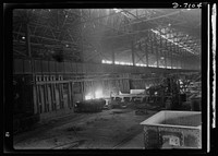 Salvage. Scrap for steel mills. Charging boxes loaded with scrap metal are dumped into electric furnaces where the scrap is melted down with steel and fluxing materials. Workers here wear dark glasses to protect their eyes from the glare. Sourced from the Library of Congress.