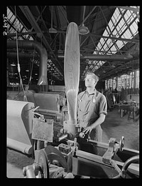 Production. Airplane propellers. John Sonesen, propeller blade grinder at a Hartford, Connecticut plant, inspects a blade for a vertical balance during the operation of grinding it to correct contours in a template. This blade will be assembled in a hydromatic mechanism to help power one of our new warplanes. Sourced from the Library of Congress.