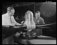 Production. Airplane propellers. A three-bladed hydromatic propeller assembly for an American warplane is tested for oil leakage at a Hartford, Connecticut, plant. With this propeller, adjustments of blade pitch are made while the plane is in action. Sourced from the Library of Congress.