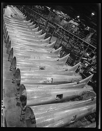 Production. B-17 heavy bomber. Tail sections of B-17F (Flying Fortress) bombers ready for assembly into the big warships of the air at the Boeing plant in Seattle. The Flying Fortress has performed with great credit in the South Pacific, over Germany and elsewhere. It is a four-engine heavy bomber capable of flying at high altitudes. Sourced from the Library of Congress.