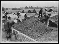 Building a new Army camp at top speed. New camps are being built with great rapidity all over the country to house not only Britain's rapidly expanding Army, but the thousands of U.S. and Canadian troops now arriving. The work is done by civilian contractors, but the Army garrison engineer is in constant supervision to see that work is as specified and that it is completed on time. Leveling soil ready to receive a concrete floor. Sourced from the Library of Congress.