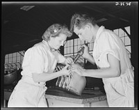 Naval air base. Corpus Christi, Texas. Learning to "keep 'em flying," trainees at the Corpus Christi, Texas naval air base, Inga Johnsen and Edwin McLelland, National Youth Administration (NYA), prepare for civil service jobs at the base. They are shown here during their eight weeks apprenticeship as riveters. Sourced from the Library of Congress.