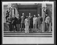 American military delegation calling on Haile Sellassie. At the conclusion of the conference, His Majesty, Haile Sellassie, Emperor of Ethiopia, posed on the palace steps with the entire American delegation. They are, left to right: F. N. Polangin, Captain Conrad, Lieutenant Colonel Baughey, Colonels Bishop and Clark, George Strompl, Captain Powers, and Tafarra Worq. These pictures are the first to be taken for publication since His Majesty's return to become a fighting member of the United Nations. Sourced from the Library of Congress.
