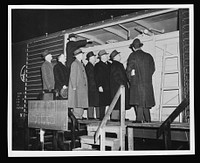 Government and railroad officials inspect the new model boxcar petroleum carrier designed to help the oil shortage in the East. It is estimated by officials of the Office of Defense Transportation that one thousand such cars could add more than 15,000 barrels to the daily receipts of petroleum by rail in the East. Sourced from the Library of Congress.