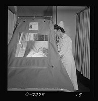 Nurse training. As students become proficient they will relieve graduate nurses from such duties as this: tending a patient in an oxygen tent. Sourced from the Library of Congress.