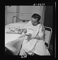 Nurse training. A patient in a Roger Anderson traction can still enjoy luncheon. Sourced from the Library of Congress.