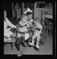 Nurse training. A nurse and the physical therapist negotiate something of a dispute over a picture book between two young patients in an orthopedic hospital. Sourced from the Library of Congress.